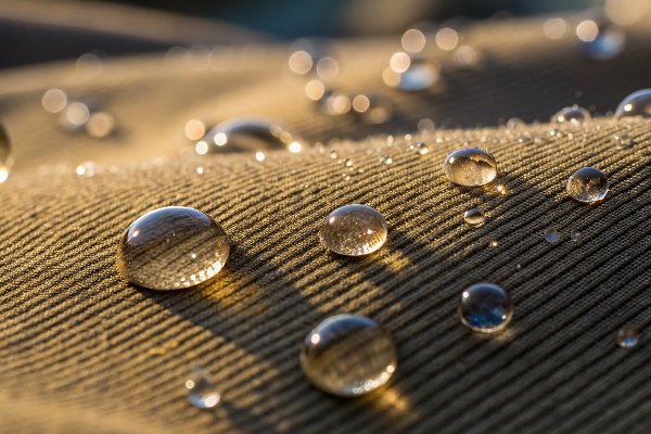 Water beading up and rolling off the surface of a corduroy bag, clearly demonstrating its waterproof quality.