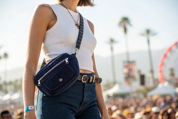 A person wearing a stylish corduroy belt bag at a music festival.